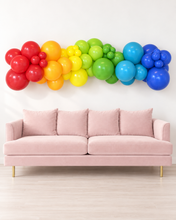 Colorful Party Hop grab-and-go balloon garland styled above a blush sofa