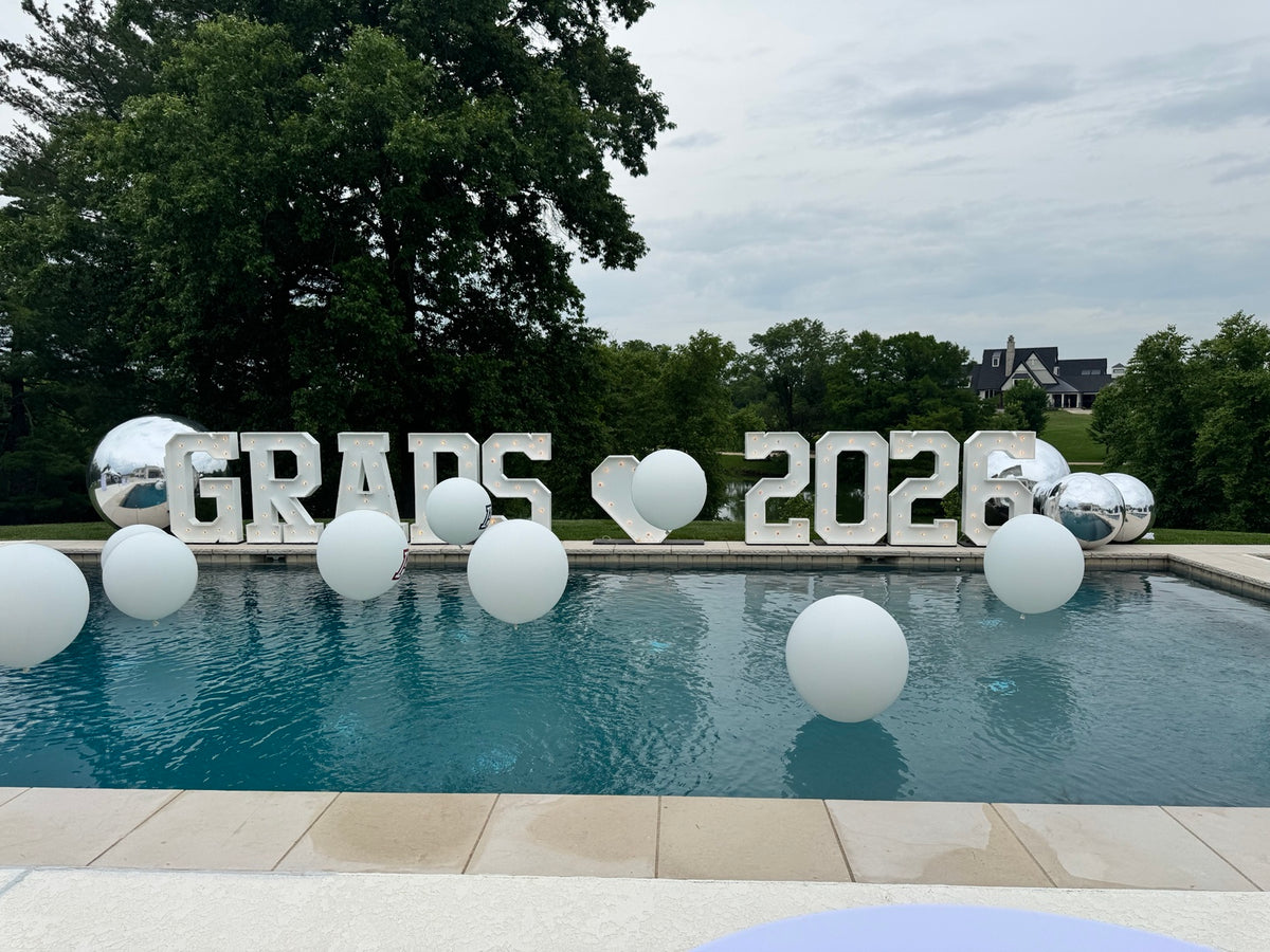 Custom graduation balloons floating in a swimming pool