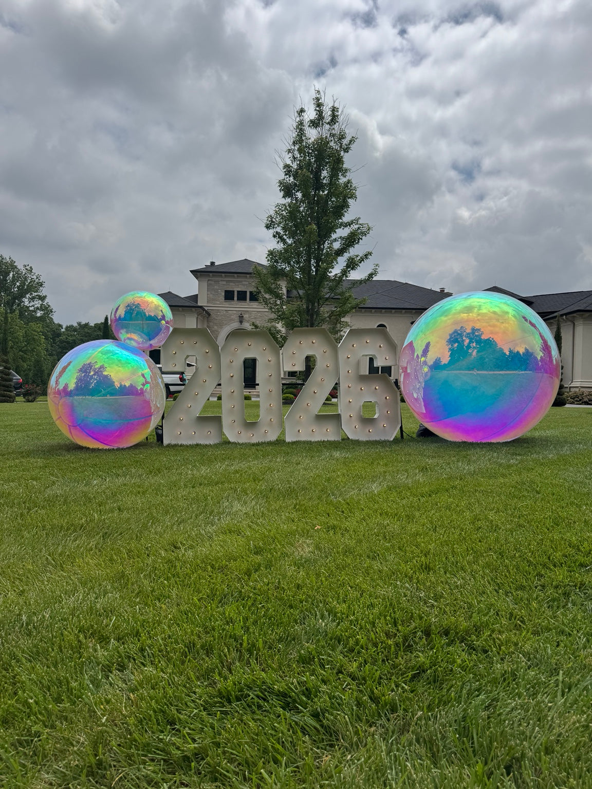 Large iridescent inflatable balls surrounding graduation numbers